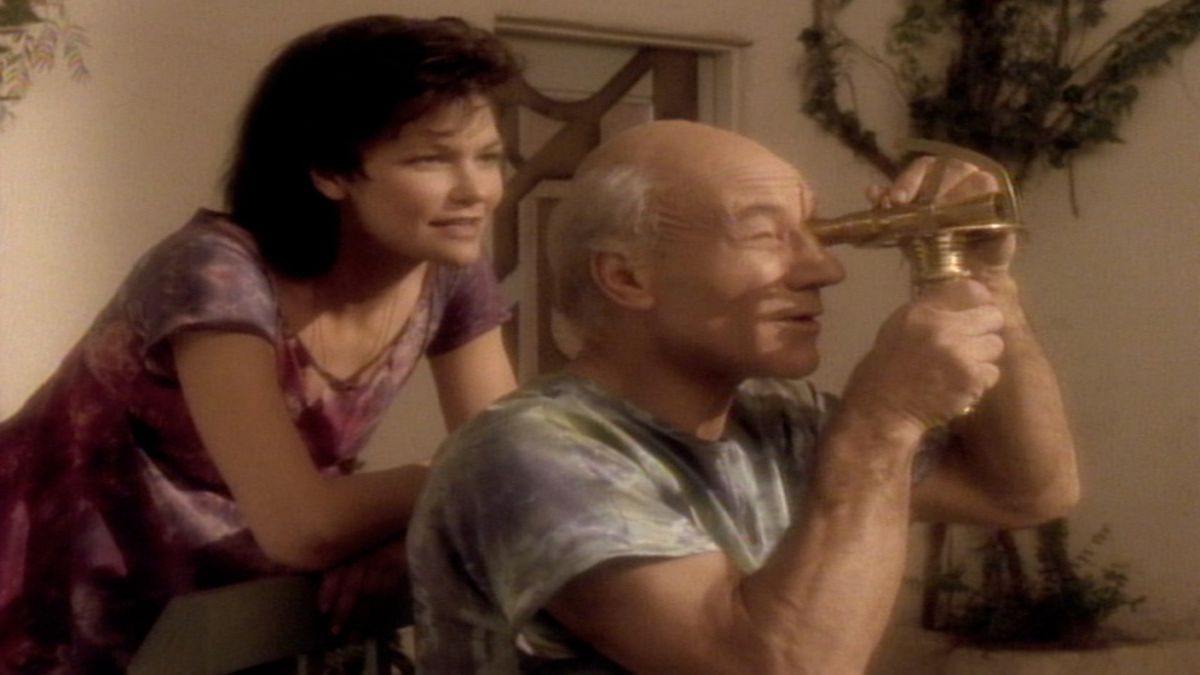 Jean-Luc Picard looking through telescope as woman looks behind him in the episode &quot;The Inner Light&quot;