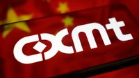 The CXMT logo is displayed on a smartphone screen placed on a reflective surface on which the flag of China is projected.