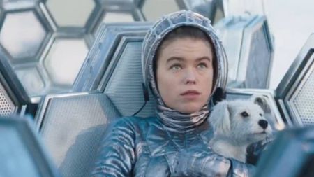 Kara Zor-El (Milly Alcock) sitting in an escape vessel, holding Krypto in her arms