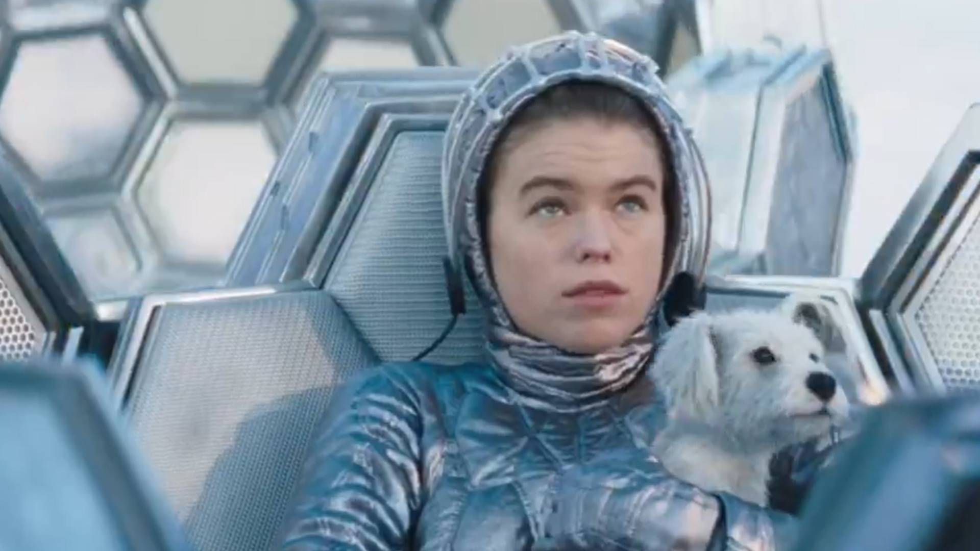 Kara Zor-El (Milly Alcock) sitting in an escape vessel, holding Krypto in her arms