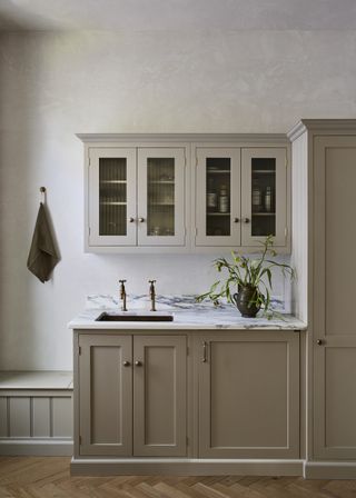 Beige painted shaker kitchen by Devol with marble countertops