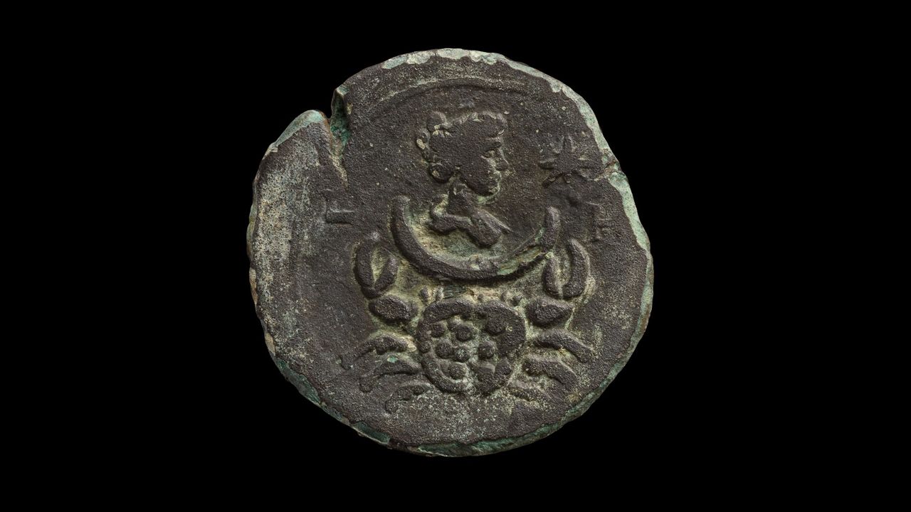 An old coin with the profile of Luna, ancient goddess of the moon. Below her face there is the cancer zodiac sign.
