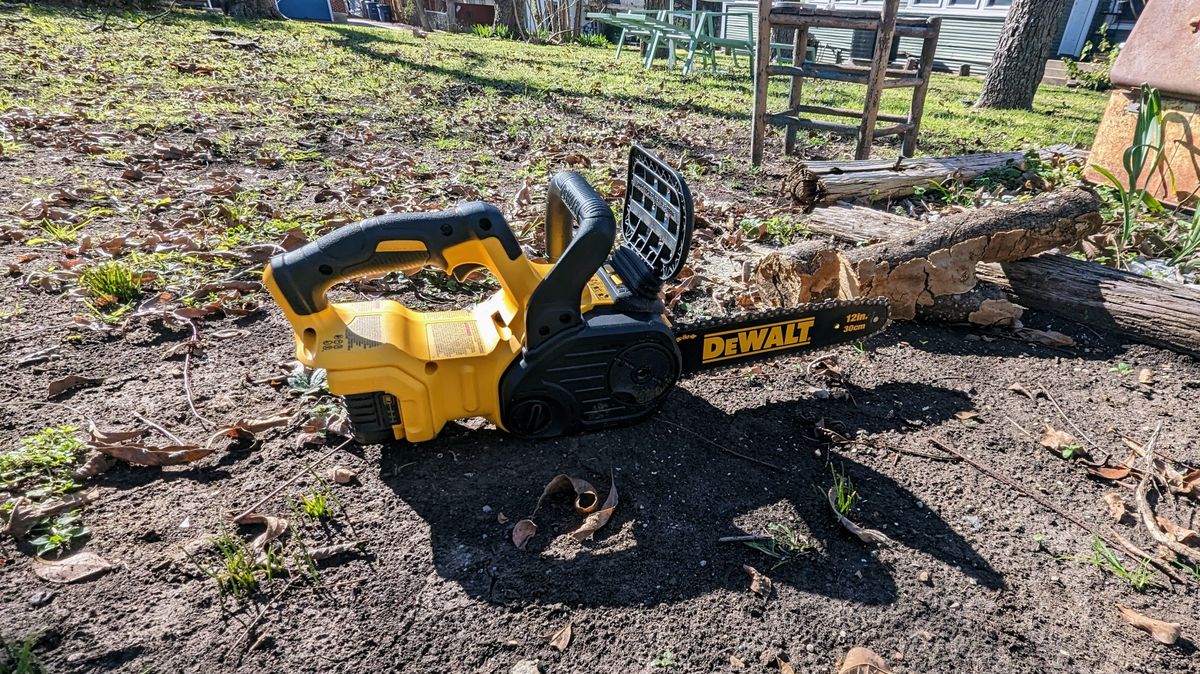 DeWalt 20V MAX XR DCCS620P1 12 in. Battery Chainsaw in a garden setting on the ground