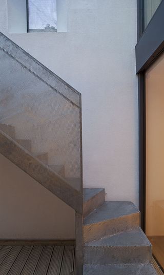 Steel stairway with steel banisters) on wood flooring and white walls