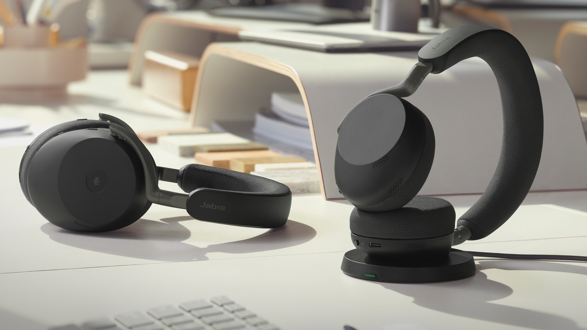 The Jabra Evolve3 85 and 75 at a desk and being worn.
