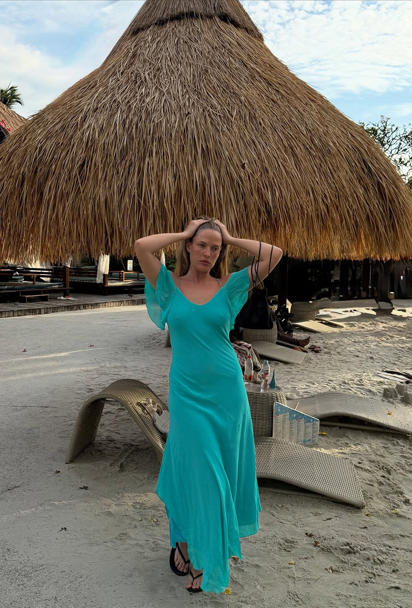Ailie Smith wearing a bright dress on a beach.