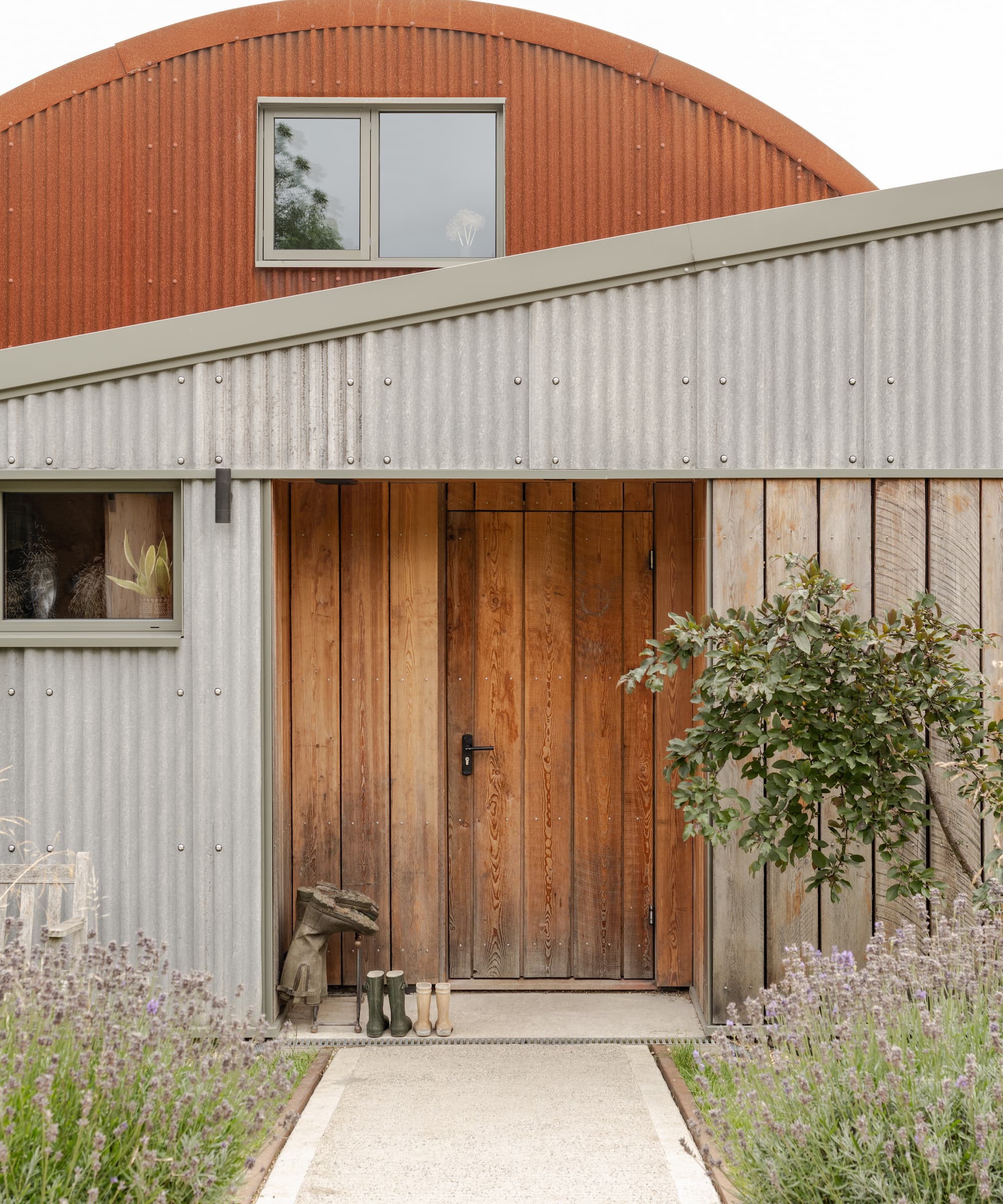 A timber larch front door and a pitched roof