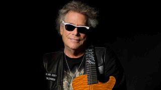 Mountain singer and guitarist Leslie West posing for a photograph with a guitar in 2009