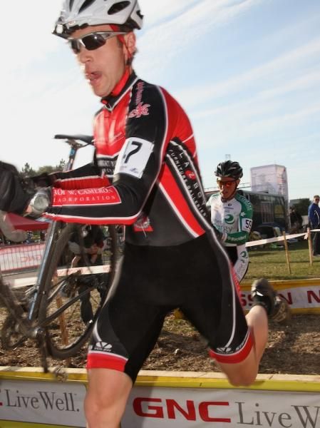 Drew Mackenzie (Island Racing Club) chased by Mark Batty (Planet Energy) through the barriers