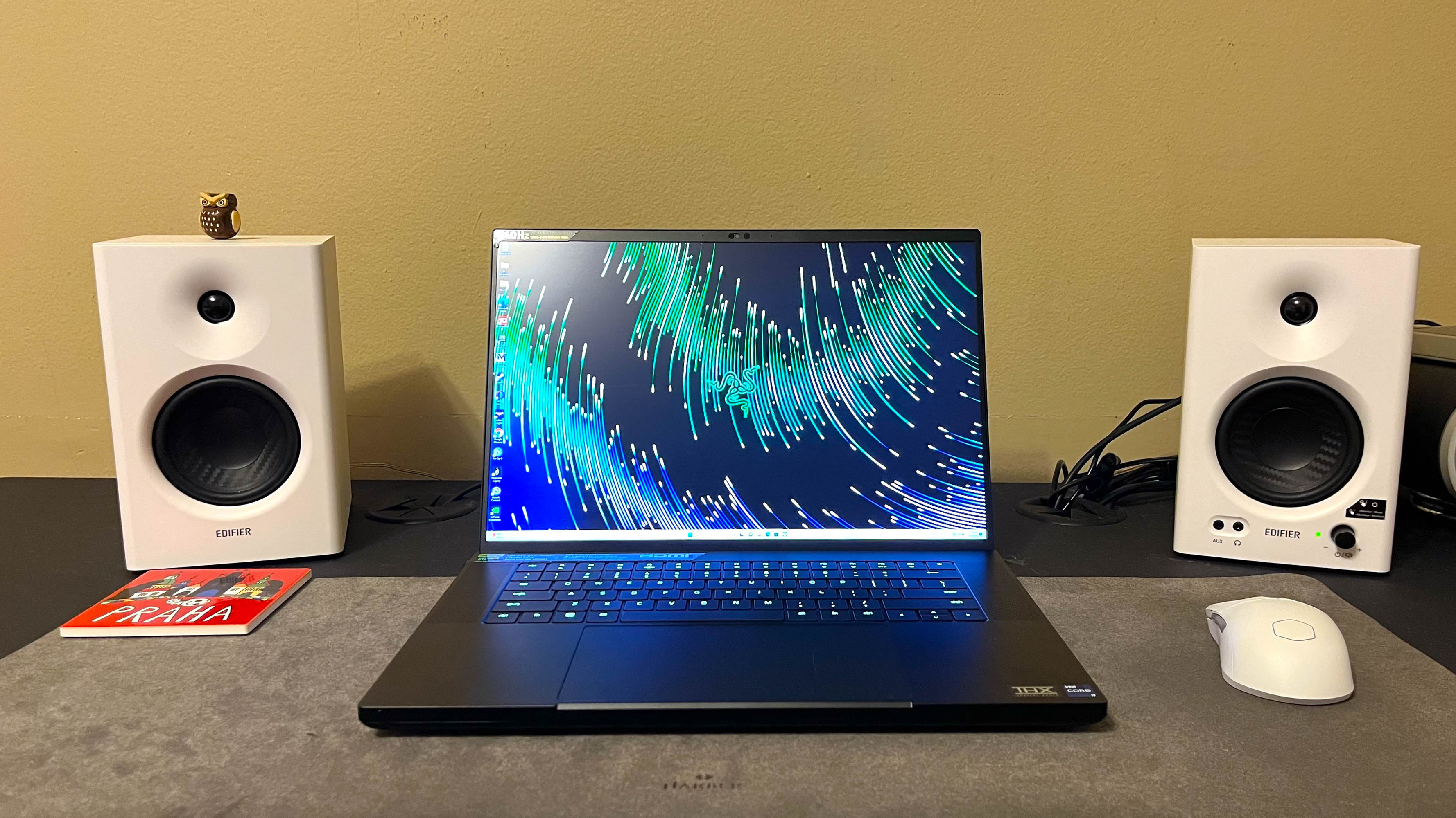 Razer Blade 16 (2023) pöydällä kahden valkoisen kaiuttimen välissä