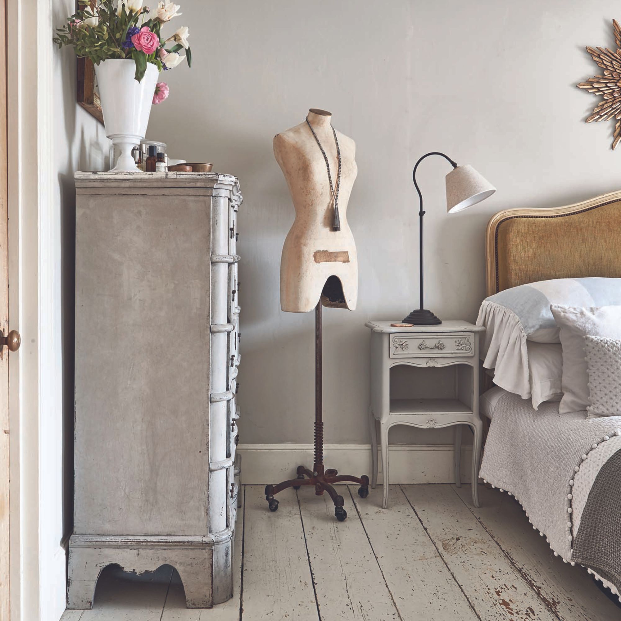 scandi-inspired bedroom with painted wooden floorboards and grey chest of drawers