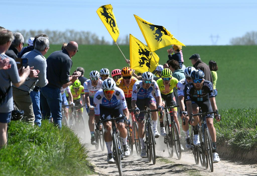 ROUBAIX FRANCE APRIL 17 LR Maciej Bodnar of Poland and Team Total Energies Rasmus Fossum Tiller of Norway and UNO X Pro Cycling Team Jannik Steimle of Germany and Team QuickStep Alpha Vinyl and the peloton compete passing through a cobblestones sector while fans cheer during the 119th ParisRoubaix 2022 Mens Elite a 2572km one day race from Compigne to Roubaix ParisRoubaix WorldTour on April 17 2022 in Roubaix France Photo by Luc ClaessenGetty Images