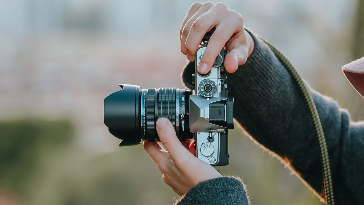 Photographer using the OM System OM-3 in an outdoor environment