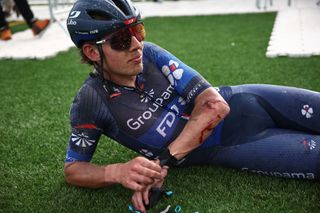 Groupama - FDJ team&#039;s New Zealander rider Laurence Pithie looks on, with his face caked in mud, and injuries sustained on his elbow after the 121st edition of the Paris-Roubaix one-day classic cycling race, 260km between Compiegne and Roubaix, northern France, on April 7, 2024. (Photo by Anne-Christine POUJOULAT / AFP)