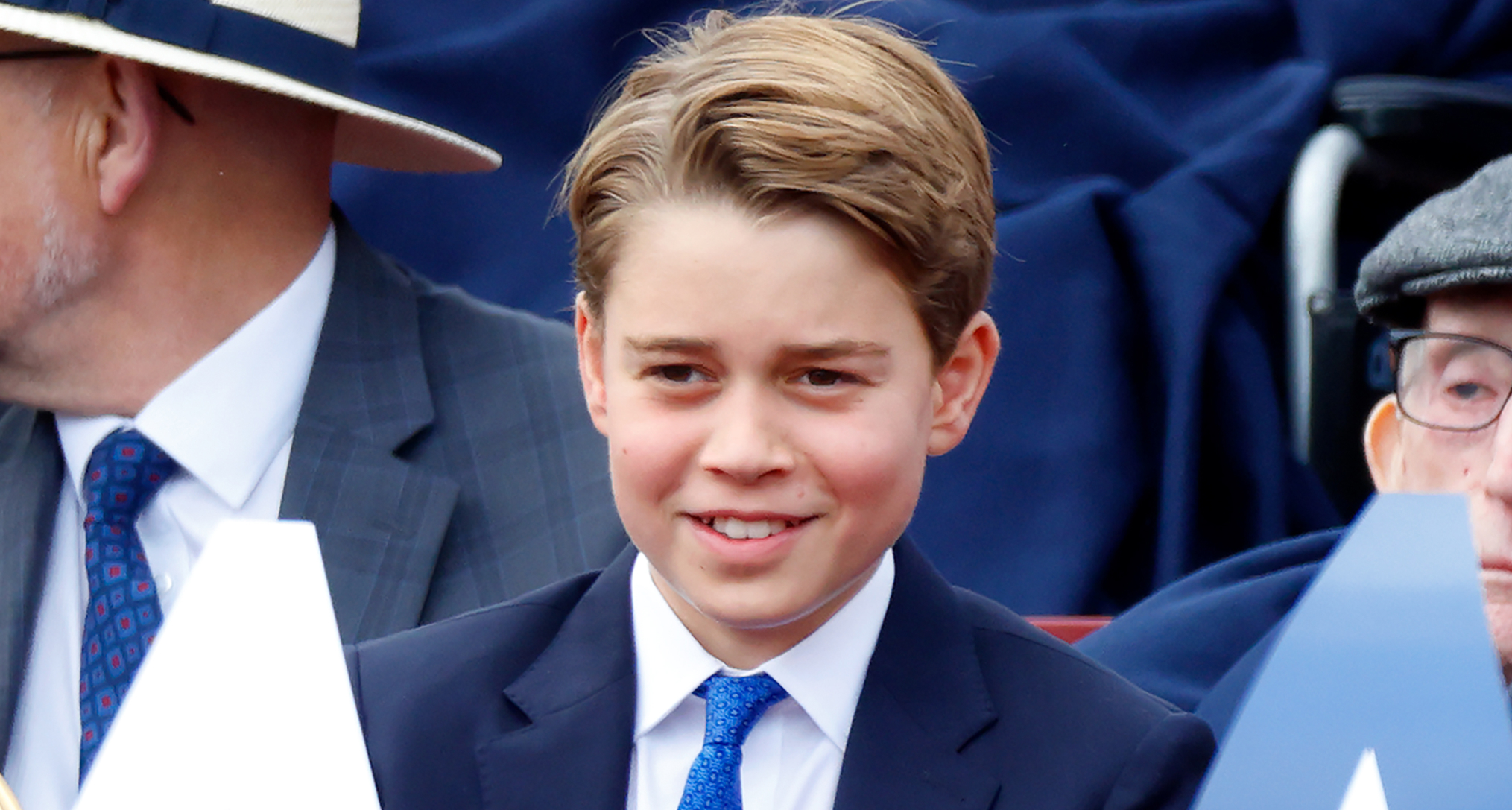 Prince George wearing a suit and tie smiling