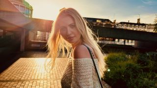 Woman with a sunset behind her