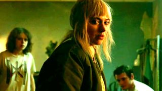Imogen Poots as Amber staring forward while standing in a room with green lighting during the film Green Room.