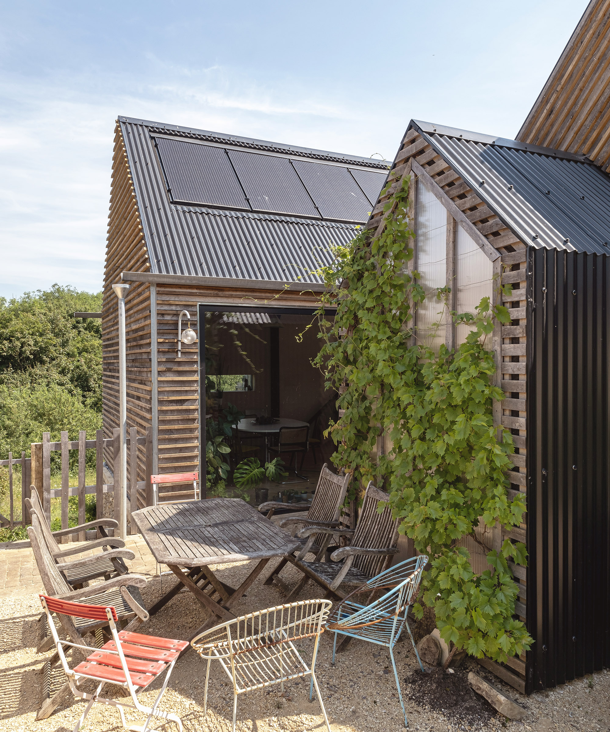 Pitched roof self build with sunny courtyard out in front with outdoor dining table