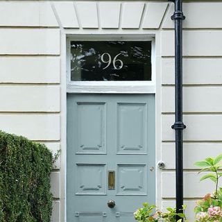 House number decal on blue front door.