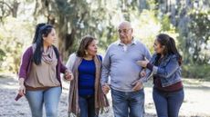 A family of four walk in the woods as they have a serious discussion.