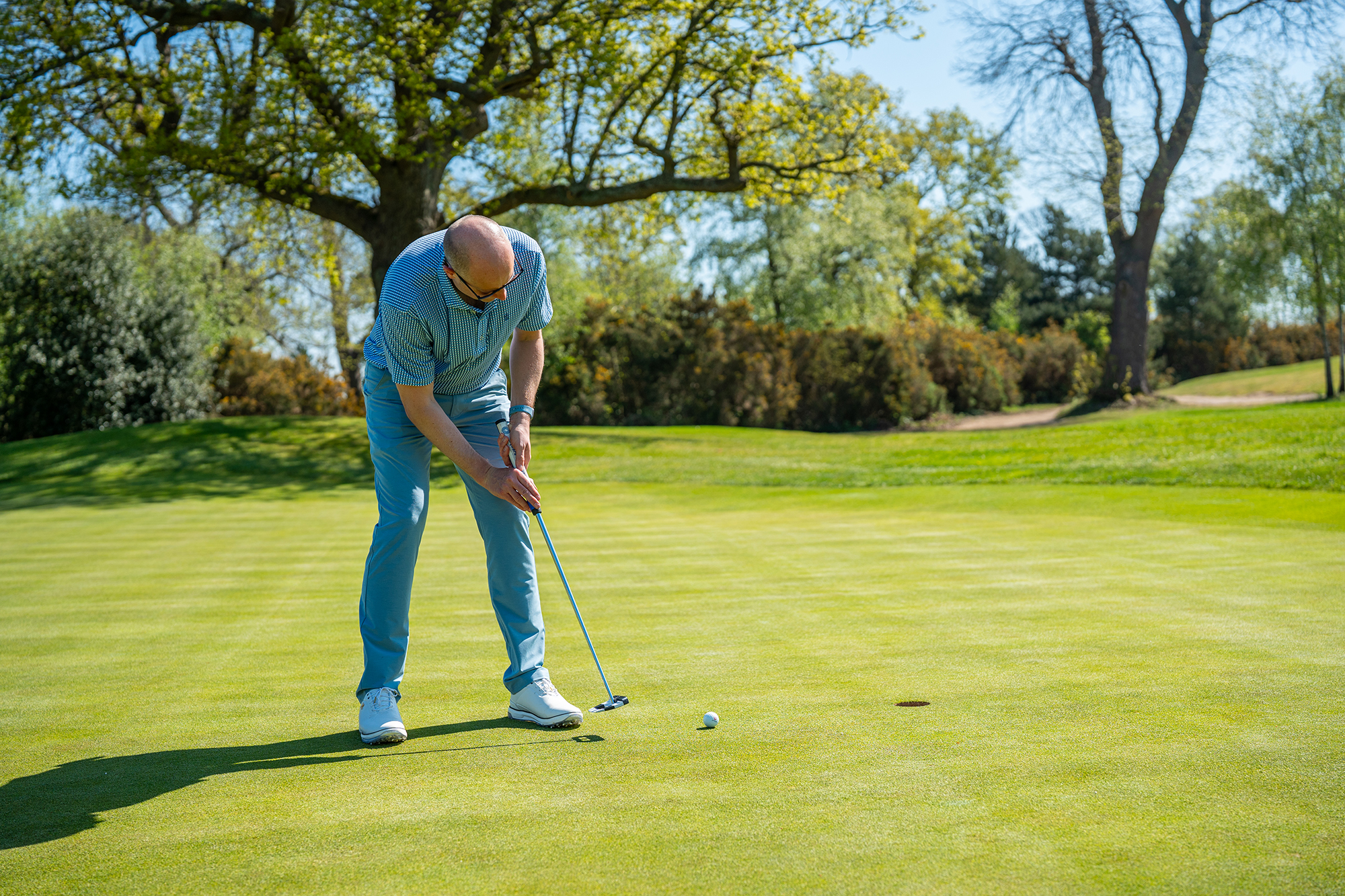 Neil Tappin hitting a putt on the green with the ball travelling to the hole