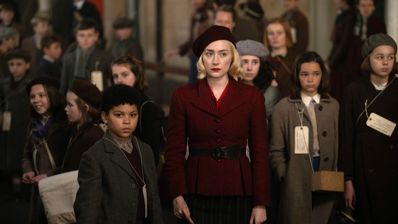 George (Elliott Heffernan) and Rita (Saoirse Ronan) stand in Paddington Station, in 1940, in the film Blitz