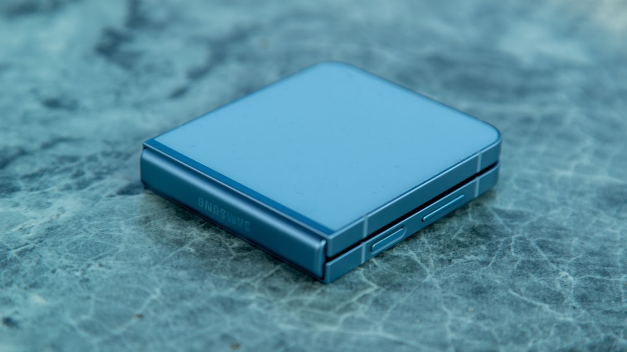Samsung Galaxy Z Flip 6 folded on a blue table