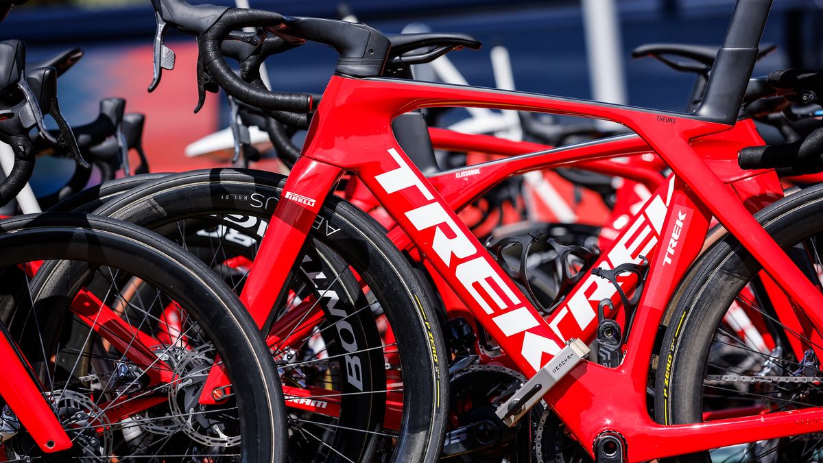 A red bicycle bearing the logo of Trek Bicycle Corporation, amidst other red bikes during a tour race.