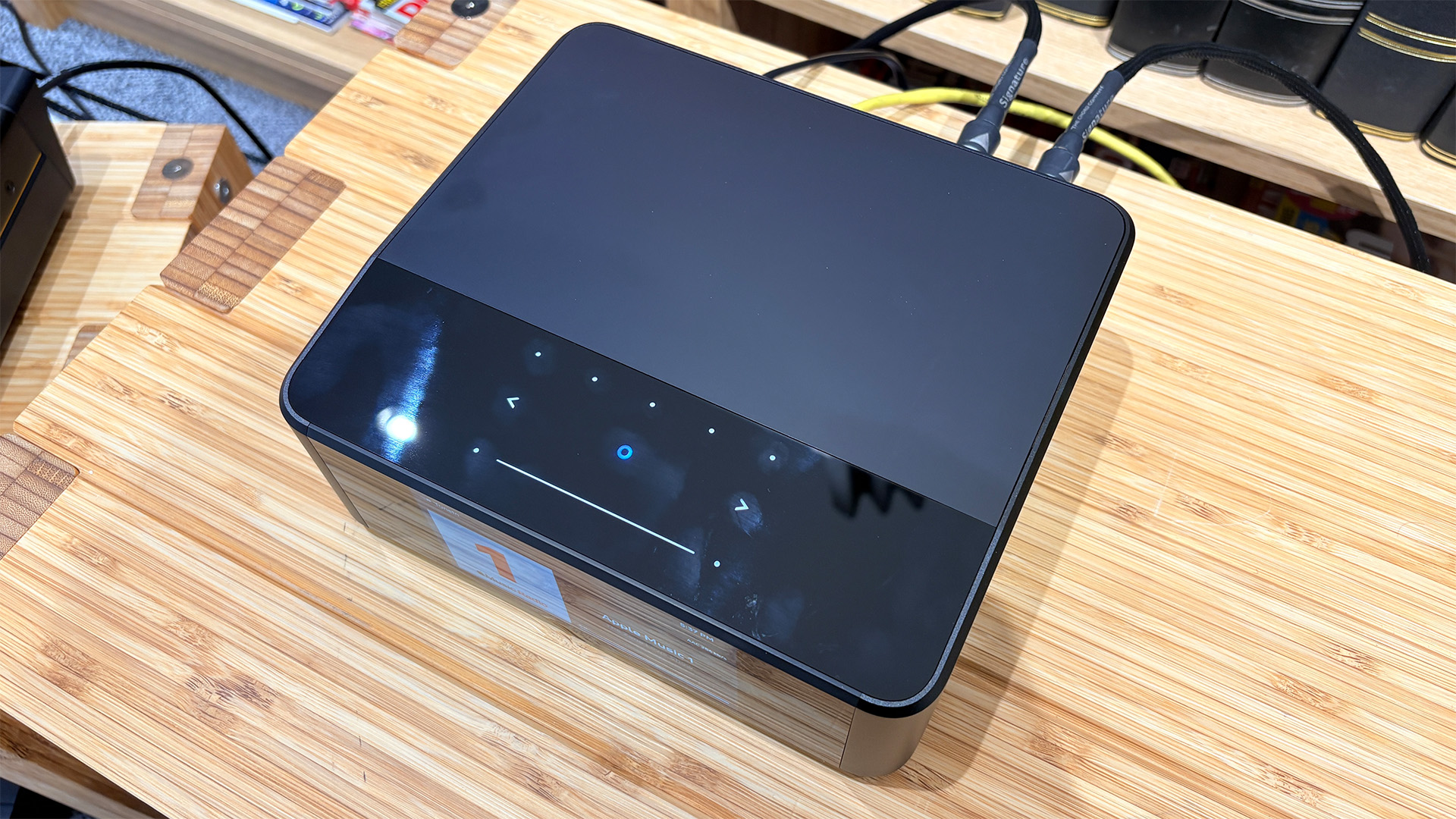 Bluesound Node Icon music streamer on wooden hi-fi rack top down view showing control panel