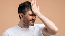 Frustrated man making facepalm showing regret and remembering a painful mistake