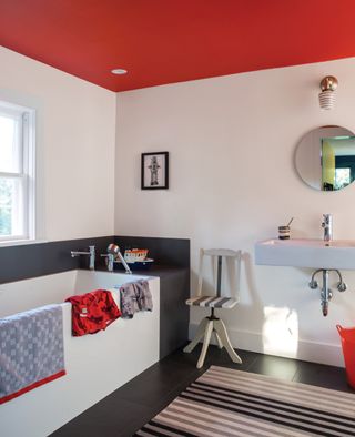 modern bathroom with white walls, a red ceiling and black floor