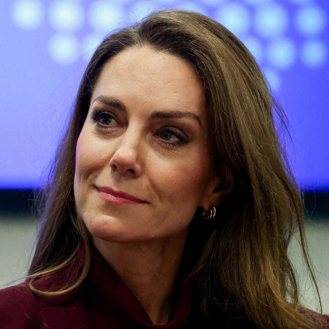 Princess Kate smiling in a burgundy suit
