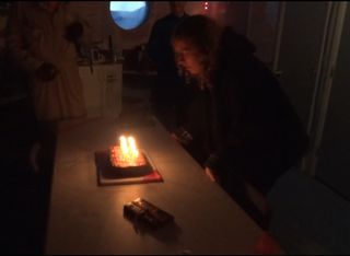 A screenshot from a video shows journalist Elizabeth Howell blowing out the candles on her birthday cake at Utah's Mars Desert Research Station in January 2014.