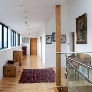 upstairs hall with white walls and wooden flooring
