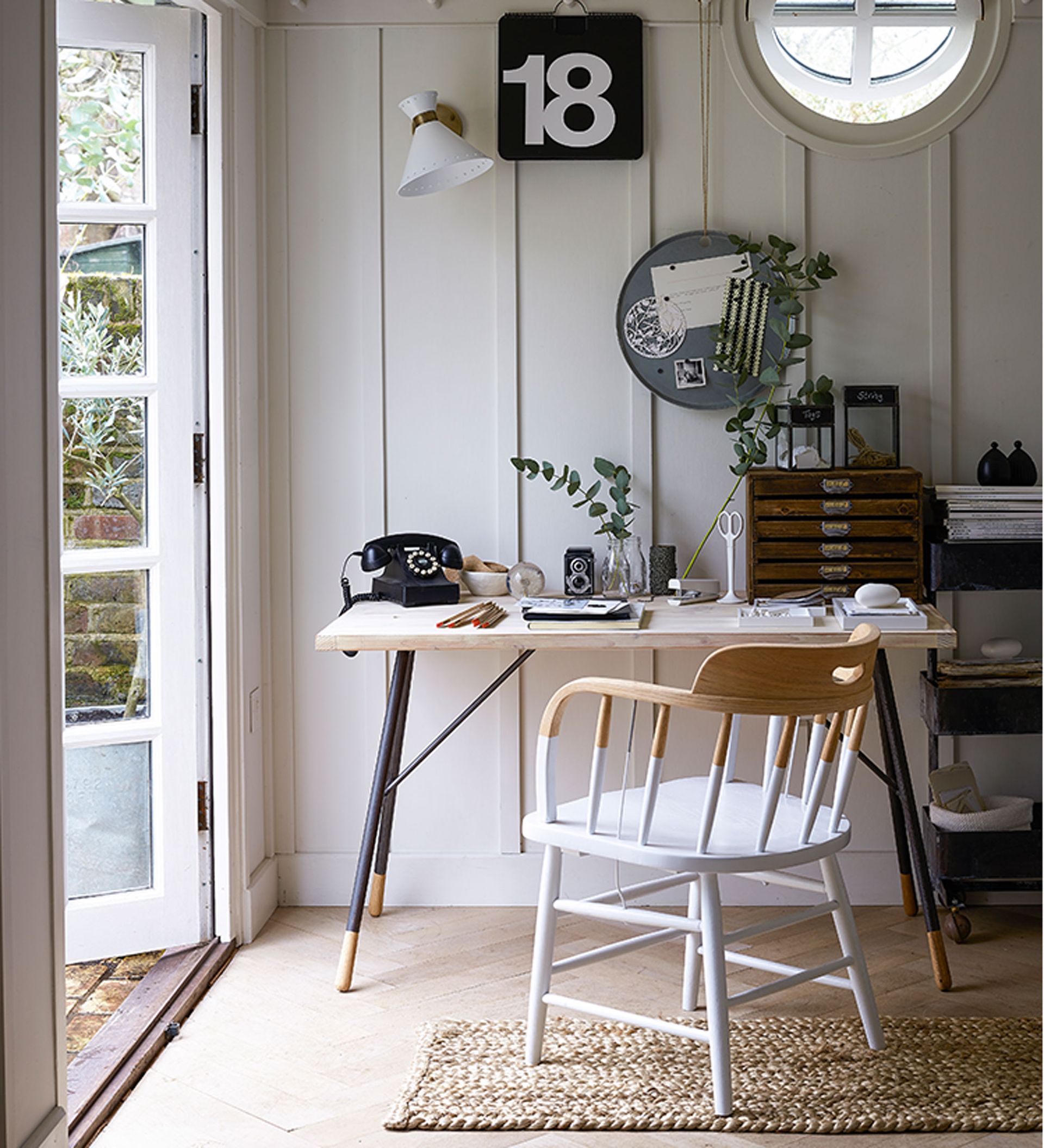 Home office layout ideas with white panelled wall and desk