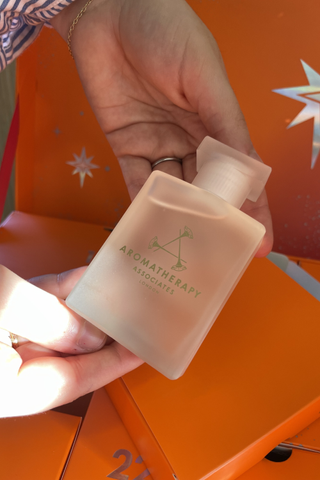 Sofia holding aromatherapy associates body oil in front of the sephora beauty advent calendar