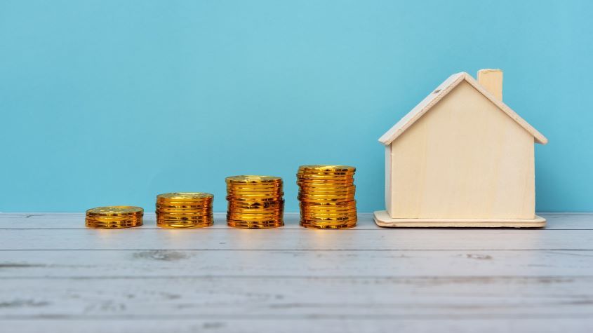 Stacks of coins next to a model house