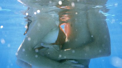 Being the other woman: A man and woman kissing in a pool