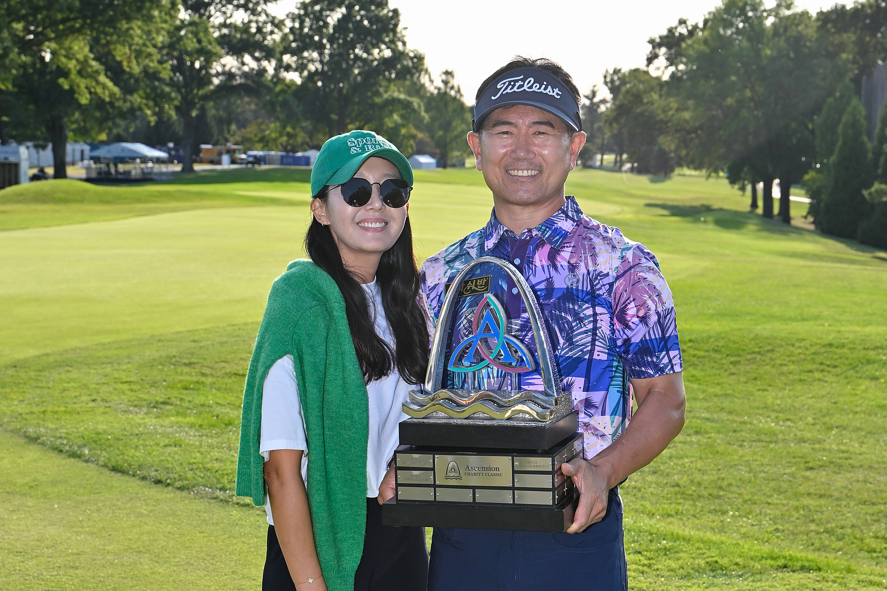 Y.E. Yang and his wife, Jeannie Yang pose with the Ascension Charity Classic trophy in 2024