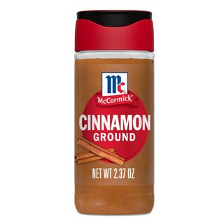 A bottle of ground cinnamon with red and black lid and red and white label