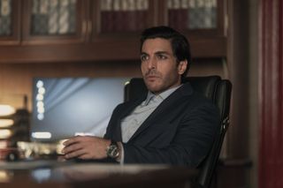 keon alexander as javed sitting at a desk in a still from the night agent season 2