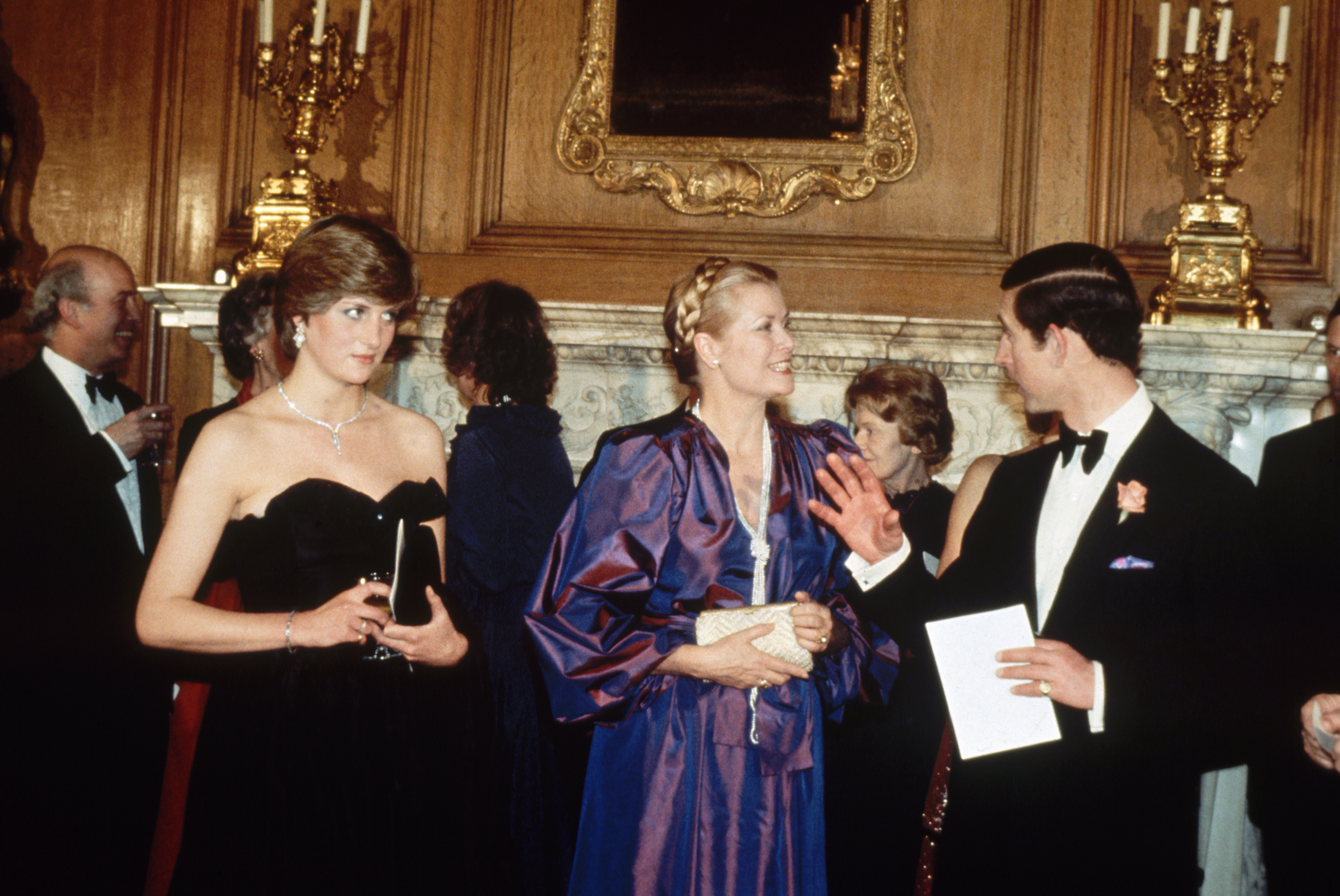 Princess Diana wears a strapless black taffeta Emanuel dress and poses next to Princess Grace Kelly of Monaco and King Charles on March 9, 1981 in London, United Kingdom