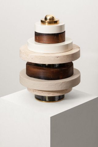 View of a sculpture made of stacked circles in different materials by Vaust pictured against a light coloured background