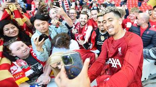 Roberto Firmino takes a selfie with Liverpool fans after his last match at Anfield, against Aston Villa in May 2023.