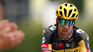 A dejected-looking Primoz Roglic wears a yellow Lazer Genesis helmet as he loses time on stage 7