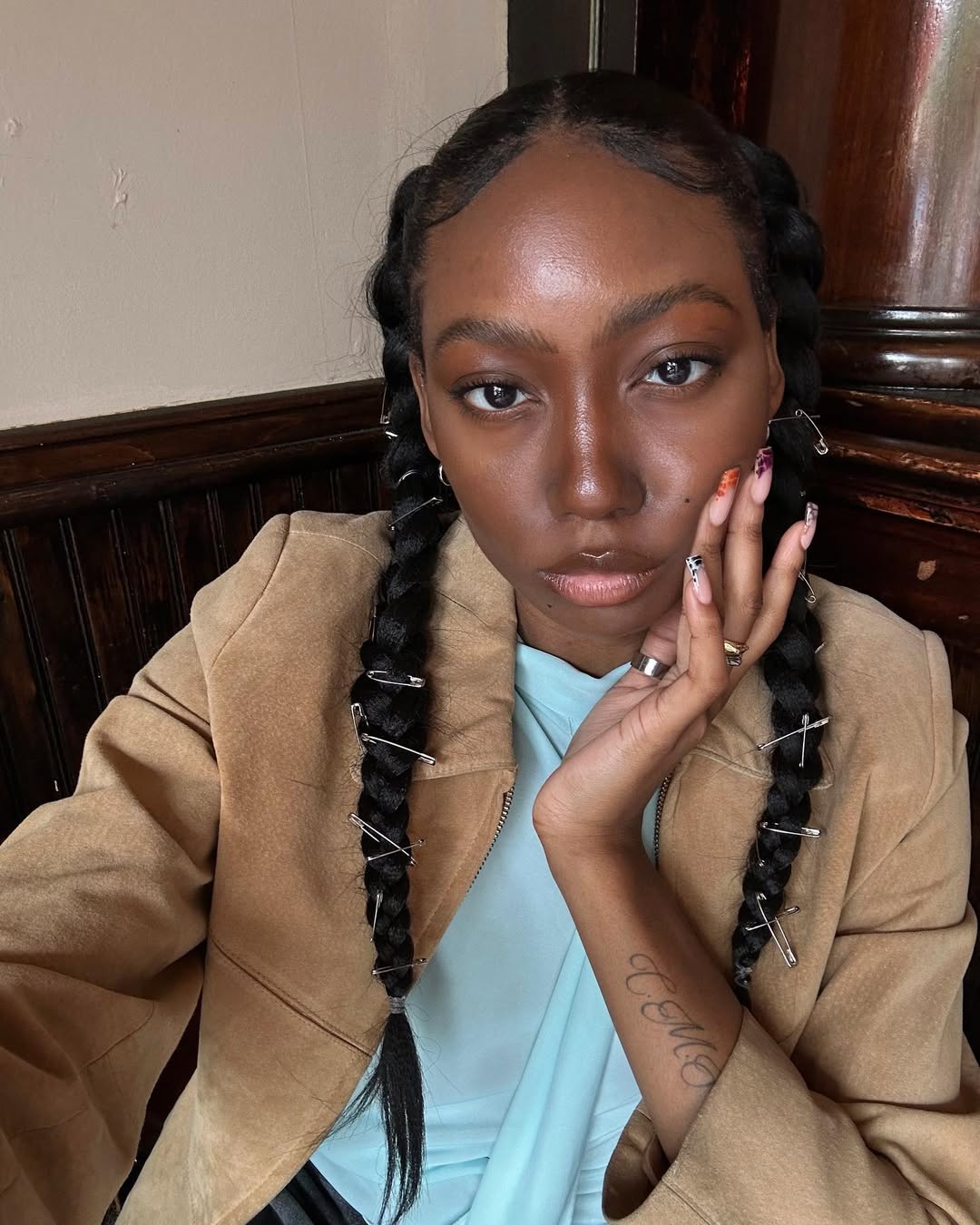 Chanel Mckinsie wears her hair in two braids with safety pin accessories