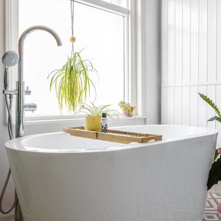 White bathroom with vertical tiles, window and bathtub