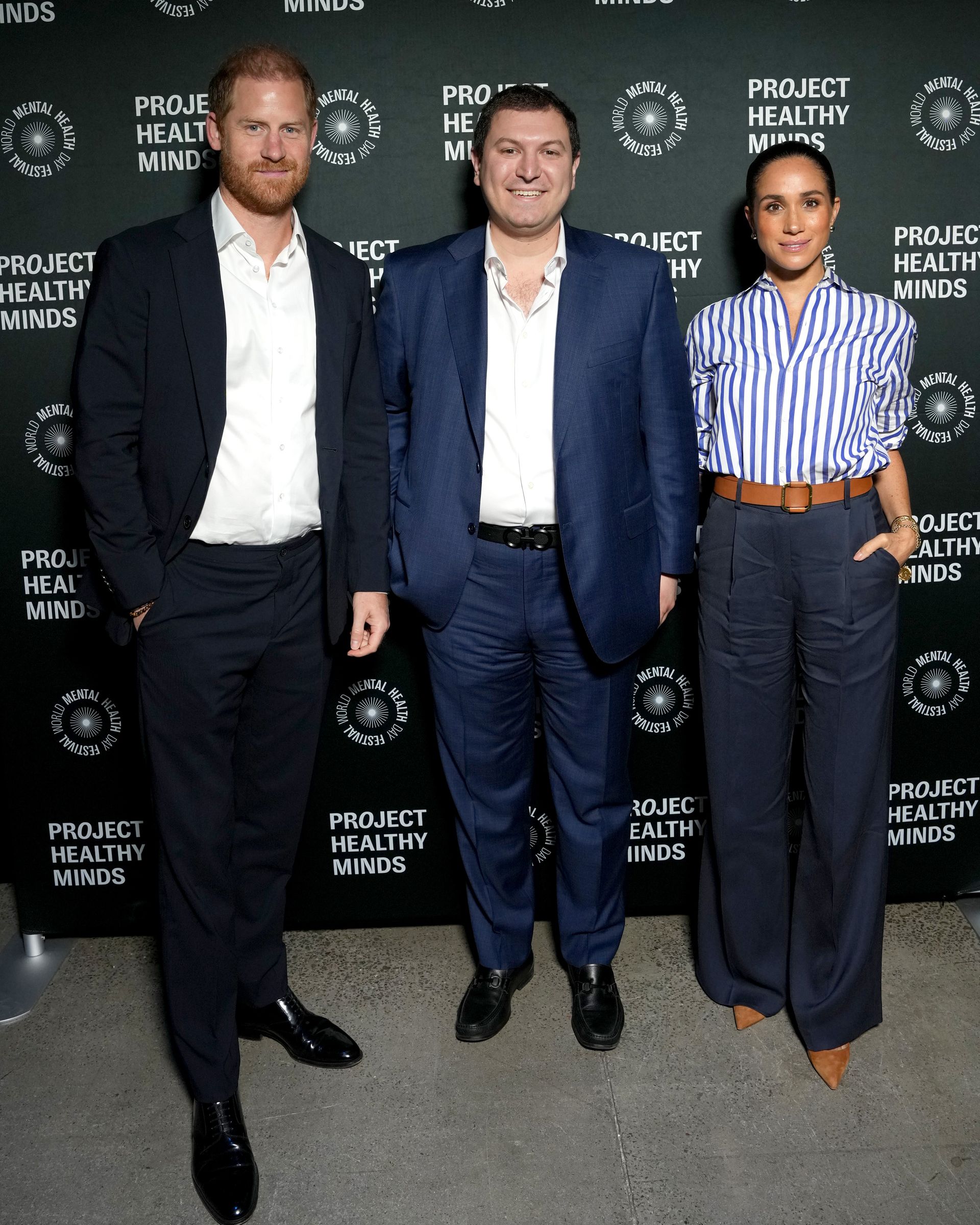 Meghan Markle wears a blue striped shirt, wide-leg pants, and a Loro Piana handbag in October 2025