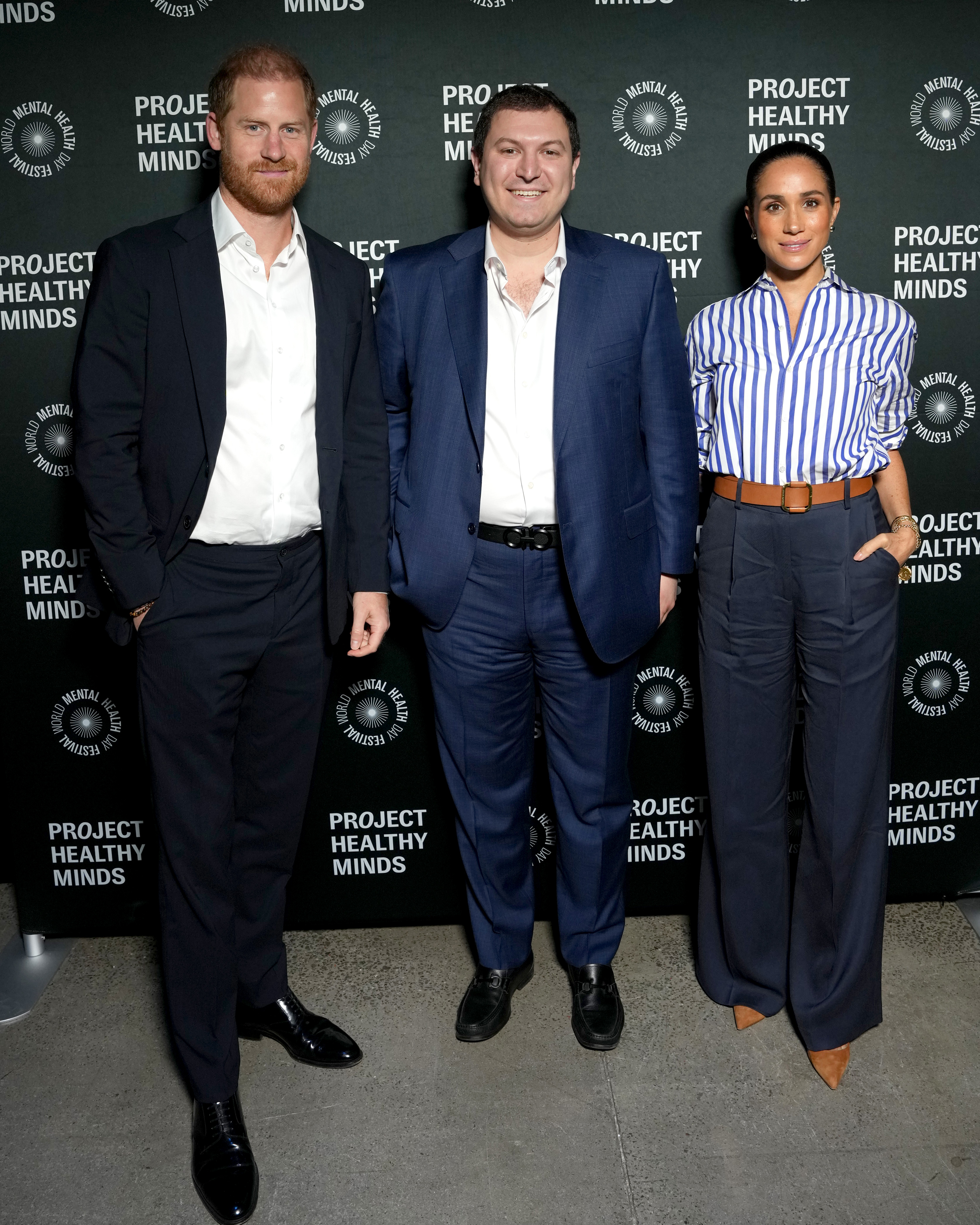 Meghan Markle wears a blue striped shirt, wide-leg pants, and a Loro Piana handbag in October 2025