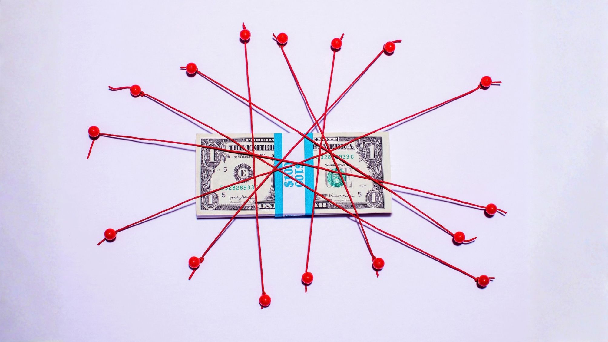 A bundle of $100 bills tied up with red string.